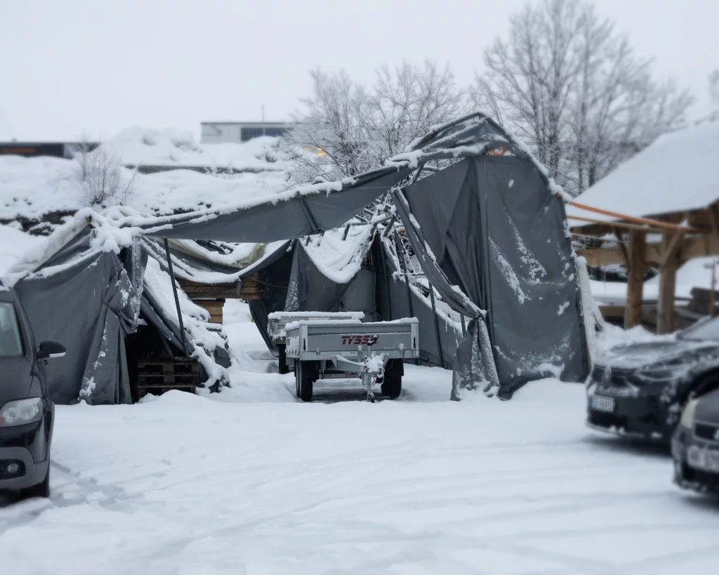 Ein kollapset rubbhall med en tilhenger foran