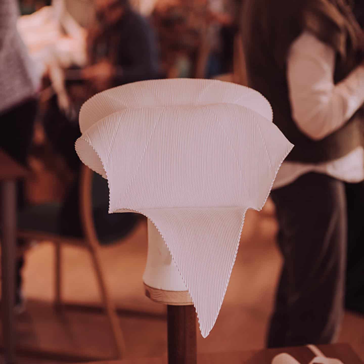 Eit tradisjonelt hvitt bunads skaut frå Hardanger. Har hundrevis av folder og brettet til fasong.